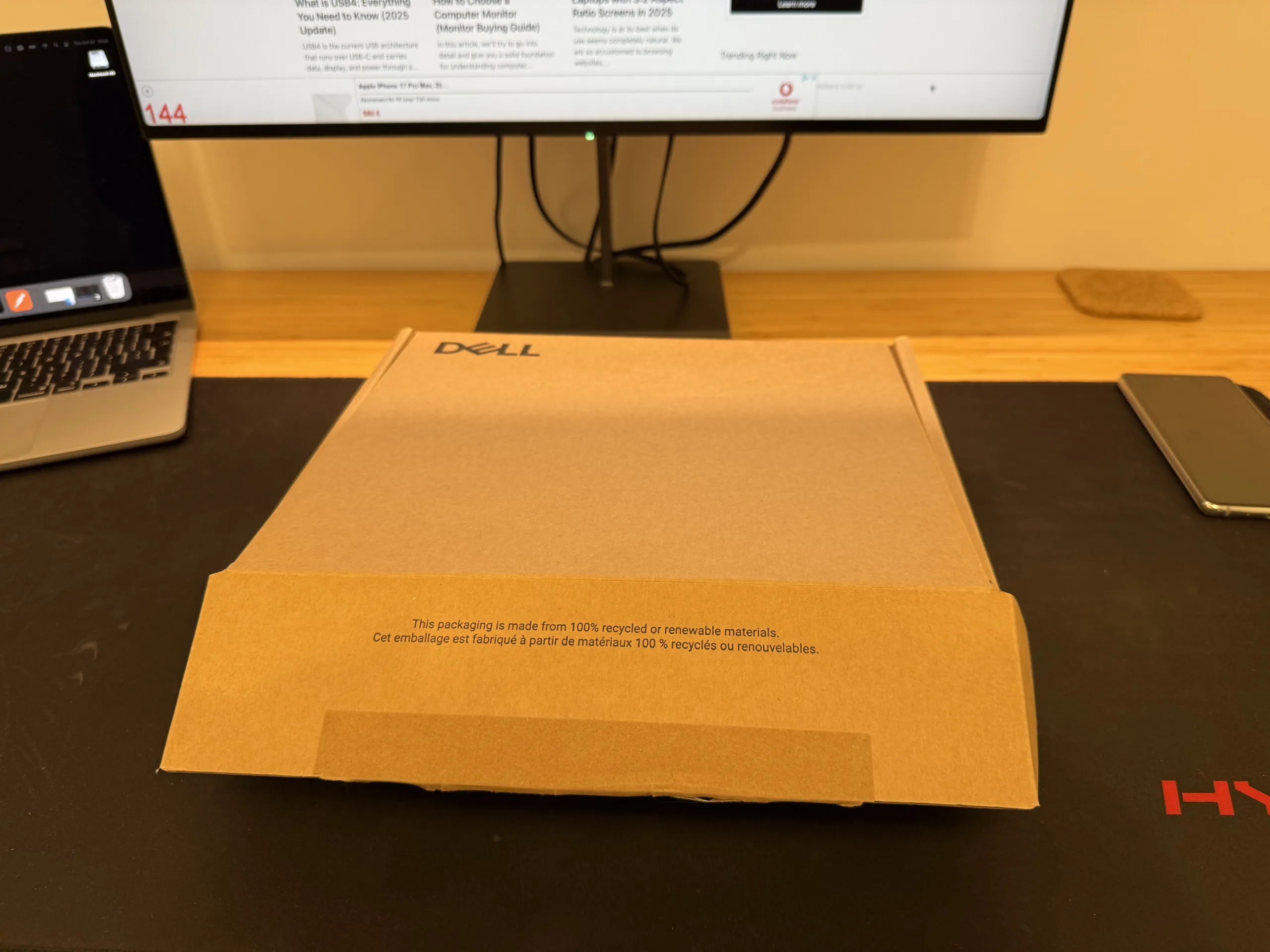 Dell docking station on a desk, plugged into a MacBook with Ethernet and display cables.