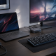 Gaming laptop docking station setup with a separate laptop power brick, external monitor, keyboard, mouse, and headset.