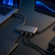 Thunderbolt hub connecting a laptop to a portable SSD, monitor, and audio interface.