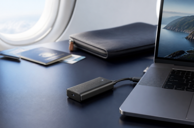 Laptop connected by USB-C to a compact cellular modem on a travel work desk