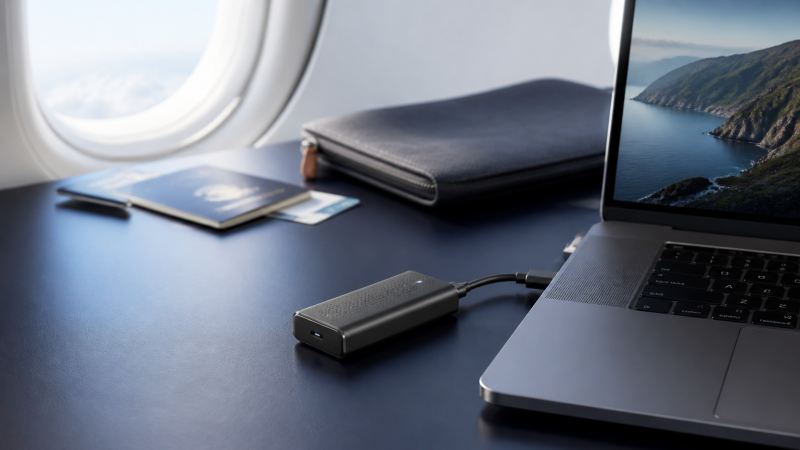 Laptop connected by USB-C to a compact cellular modem on a travel work desk