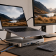 USB-C laptop stand with integrated hub ports, Ethernet, card reader, and external display connected at a desk